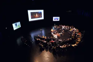 © Lucas Breuer Fishbowl-Teilnehmer:innen sitzen in einem zweireihigen Stuhlkreis um ein Podium auf der Hauptbühne im Festspielhaus Bregenz © Lucas Breuer