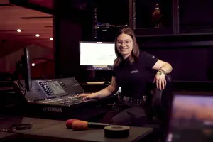 © Anja Koehler Veranstaltungstechnik-Lehrling Fiona sitzt vor einem Mischpult und einem Screen © Anja Koehler