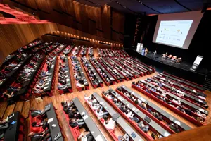 © Matthias Rhomberg, LpS & TiL Vollbesetzter Großer Saal mit Parlamentbetischung und großer Leinwand und Podium auf der Vorbühne im Festspielhaus Bregenz © Matthias Rhomberg, LpS & TiL
